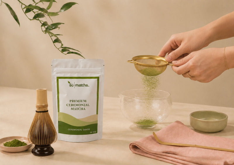Person preparing tea with a whisk and a bowl on a beige background